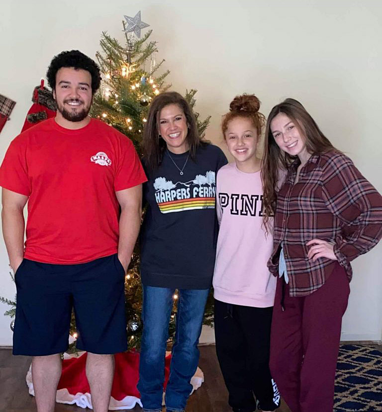 A group of people standing in front of a christmas tree.