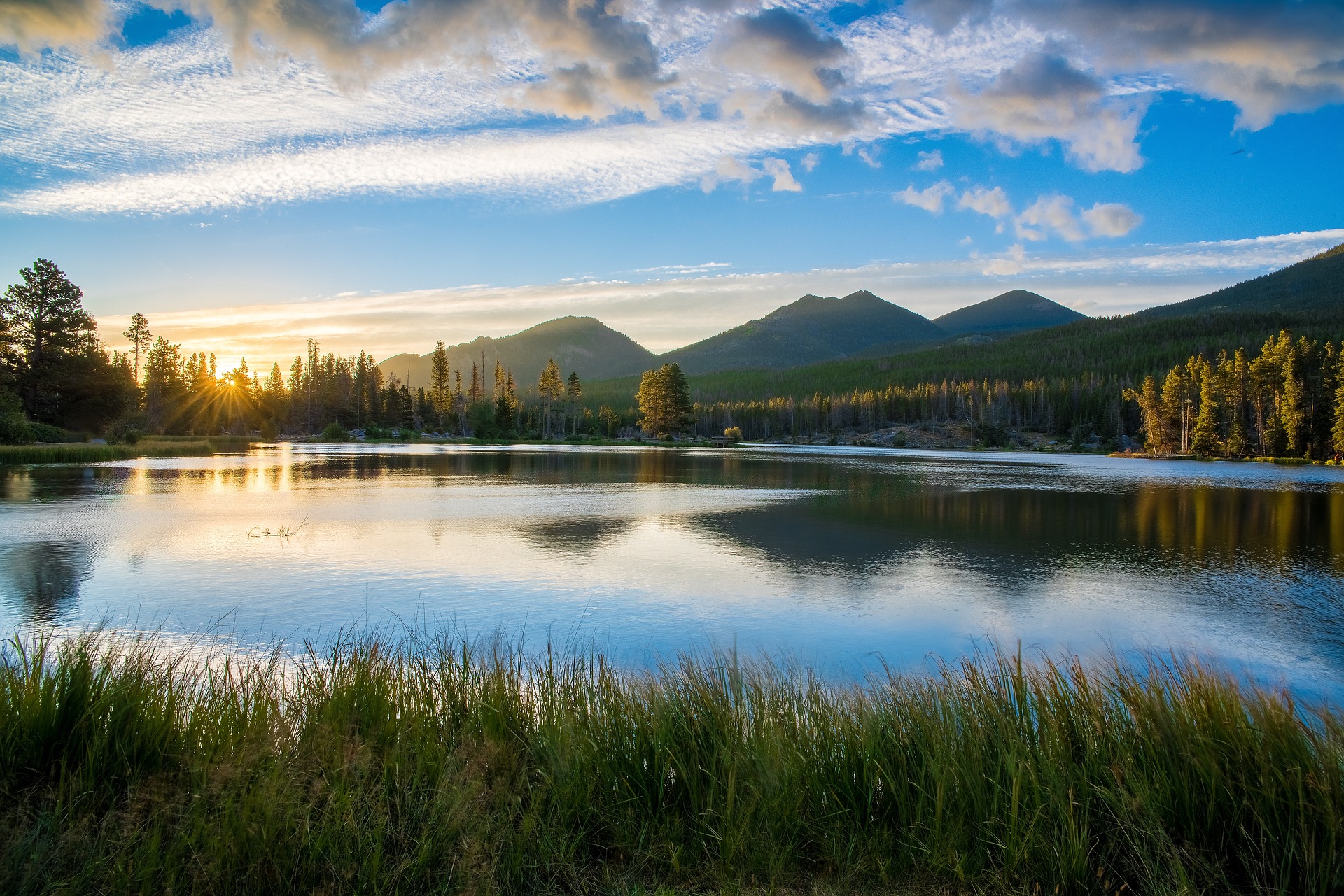 A lake with mountains in the background at sunset.